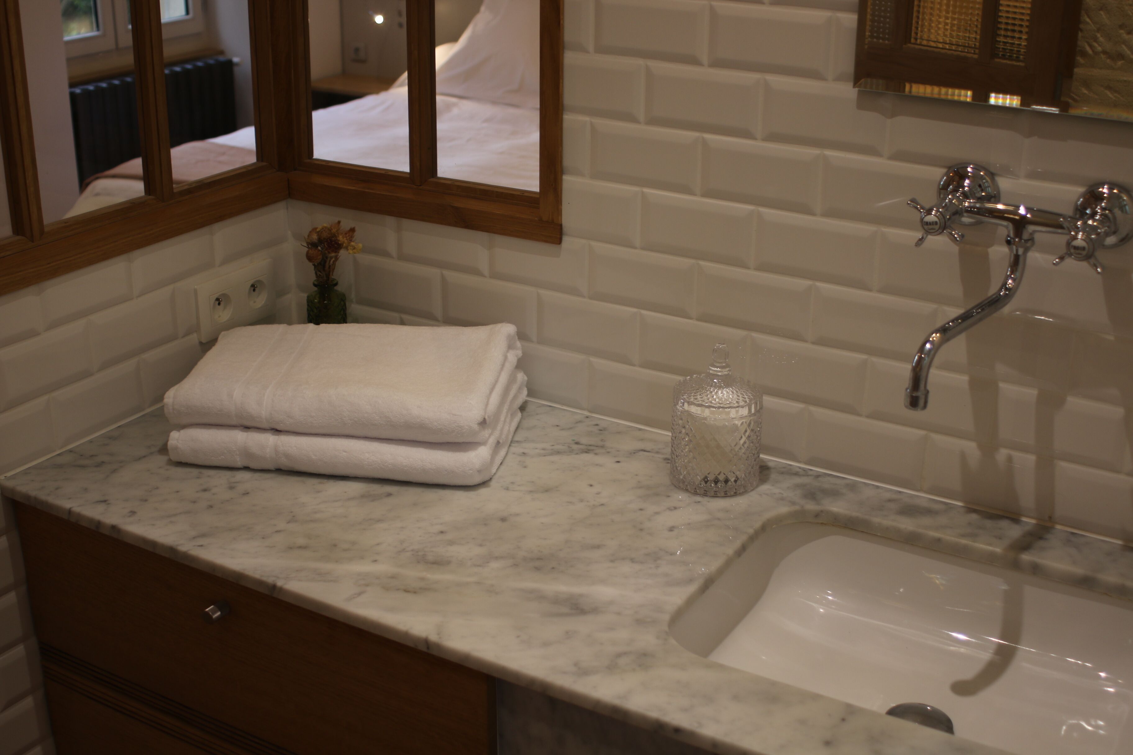Un baño con encimera de mármol, un lavabo y un espejo.