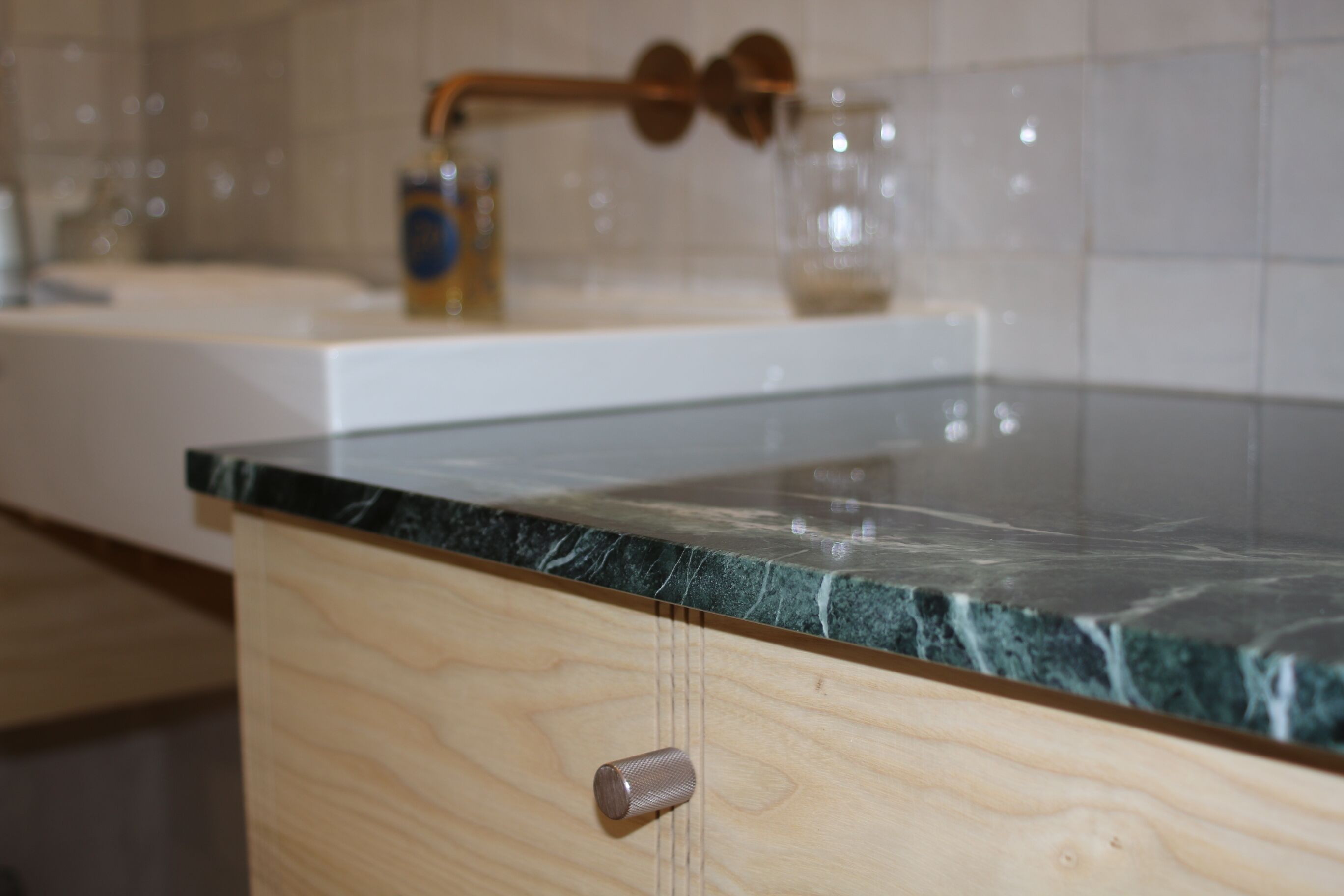 A kitchen with a wooden cabinet and a marble countertop.