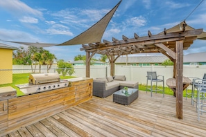An outdoor deck with a grill, seating area, and a pergola. - Pet-Friendly Fort Pierce Home w/ Pool & Kayaks! (Fort Pierce)