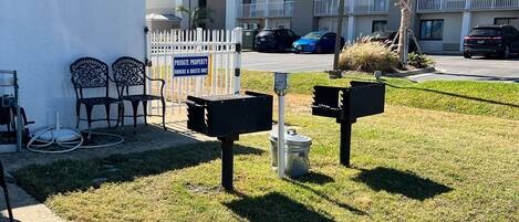 A gated area with a sign indicating private property for owners and guests only. There are two metal mailboxes and a utility pole with a trash can nearby.