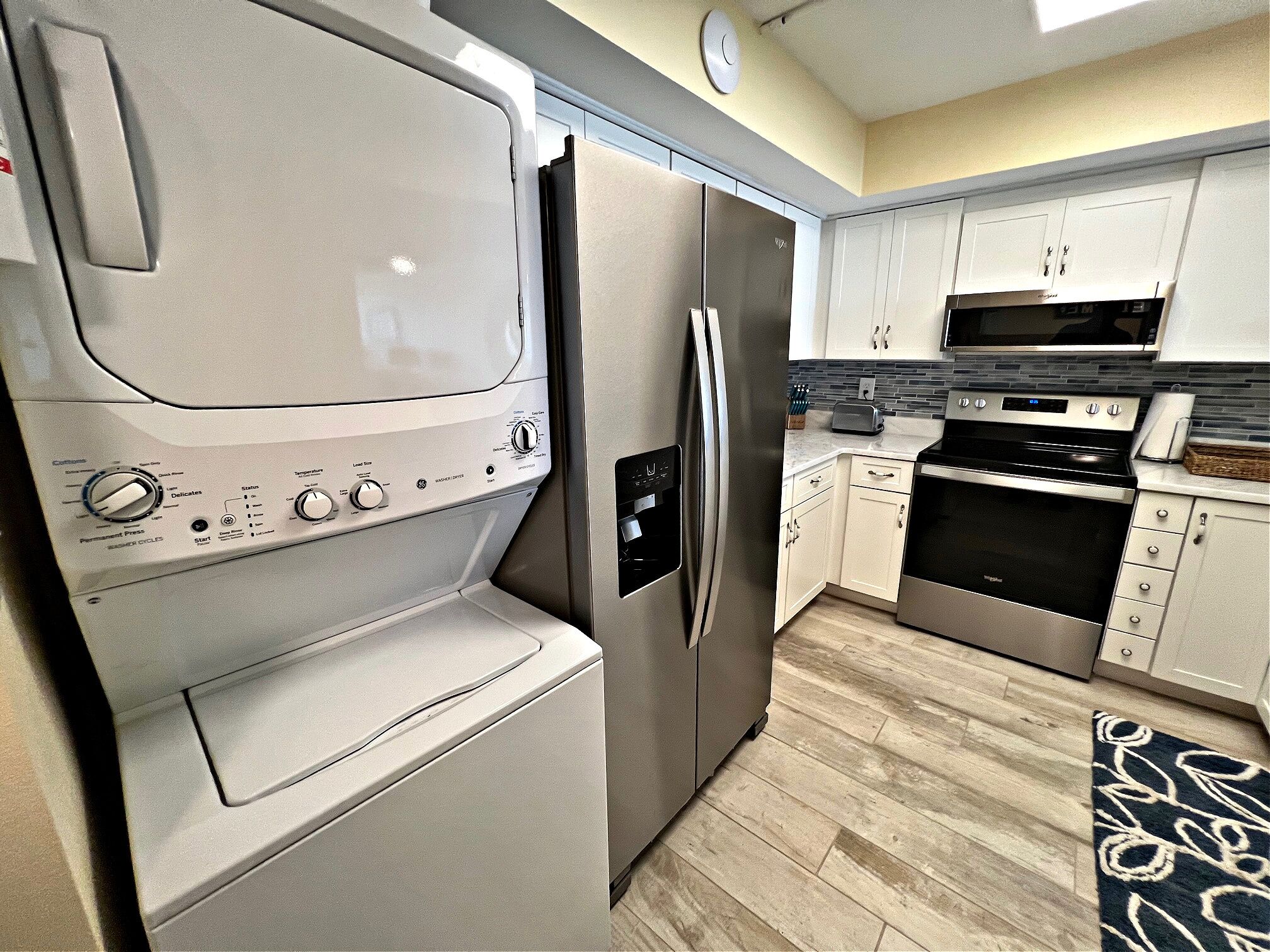 A modern kitchen with stainless steel appliances, including a refrigerator, oven, and microwave.