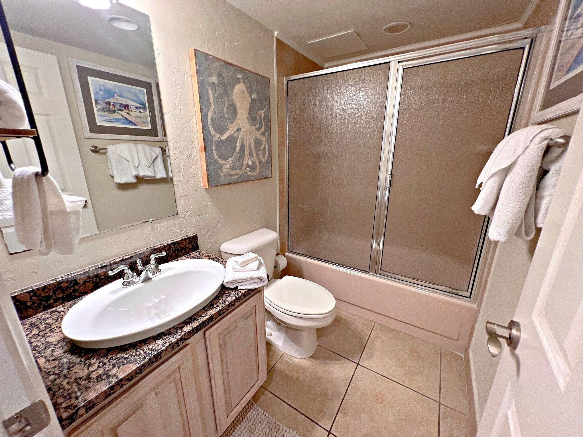 A bathroom with a sink, toilet, and shower.