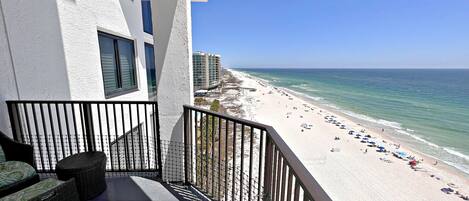 A balcony with a view of a beach and ocean.