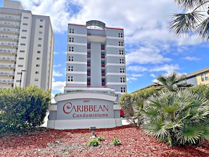 A Caribbean Condominiums building with a modern design, featuring multiple balconies and a central tower. - Caribbean (Gulf Shores)