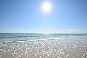 A beach with clear skies and sunlight reflecting on the water. - Caribbean (Gulf Shores)