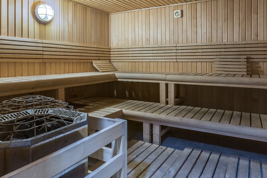 Una sauna con bancos de madera y sistema de calefacción central.