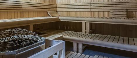 Una sauna con bancos de madera y sistema de calefacción central.