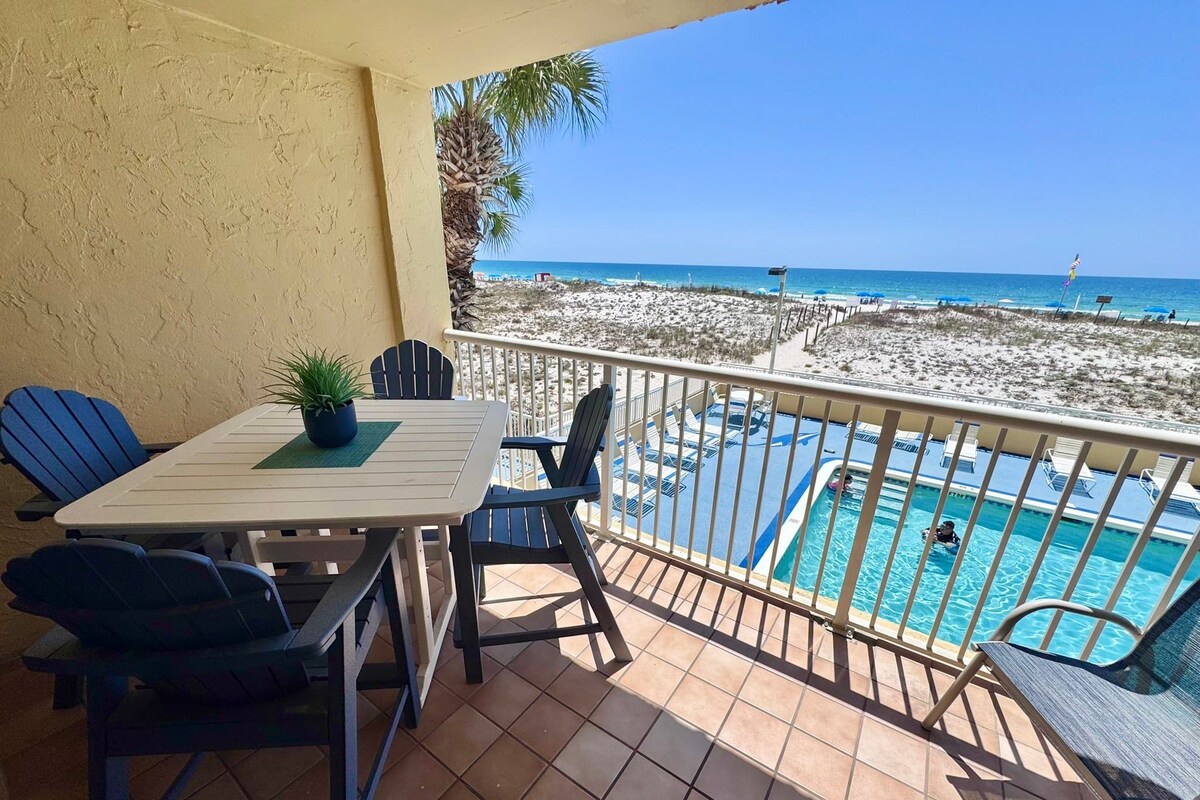 Ein Balkon mit Pool, Stühlen und Blick auf den Strand.