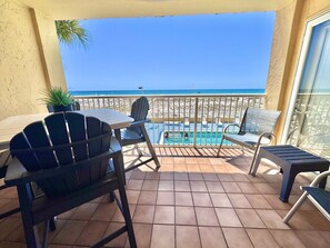 Un balcon avec une piscine, des chaises et une vue sur la plage.