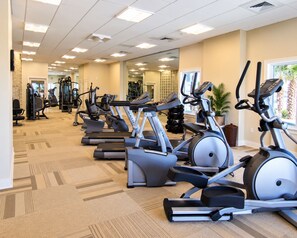 A gym with multiple treadmills, exercise bikes, and weight machines. - Escapes To The Shores (Orange Beach)