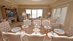 A dining area with a round table set for six, surrounded by six chairs.