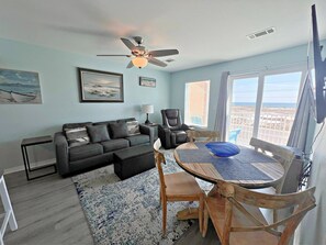 A living room with a sofa, a coffee table, a chair, a massage chair, and a ceiling fan. - Grand Beach Resort (Gulf Shores)