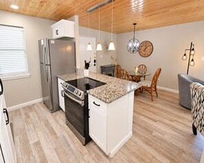 A modern kitchen with a built-in oven, refrigerator, and granite countertop. - Gulf House (Gulf Shores)