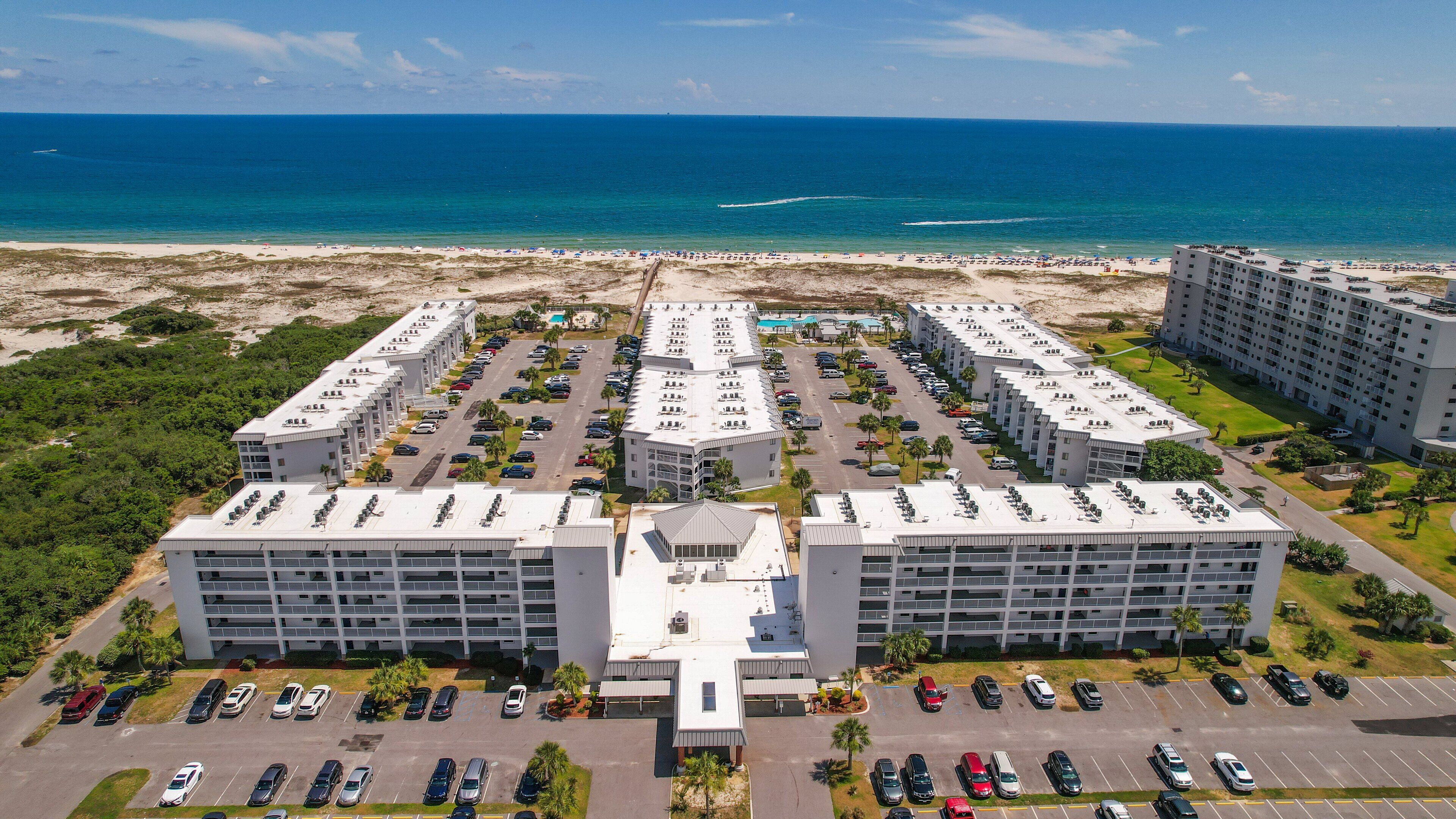 A hotel with a central courtyard, multiple parking levels, and a beach view.
