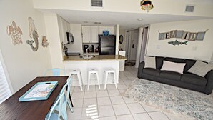 Um espaço habitacional compacto com cozinha, área de refeições e sala de estar.