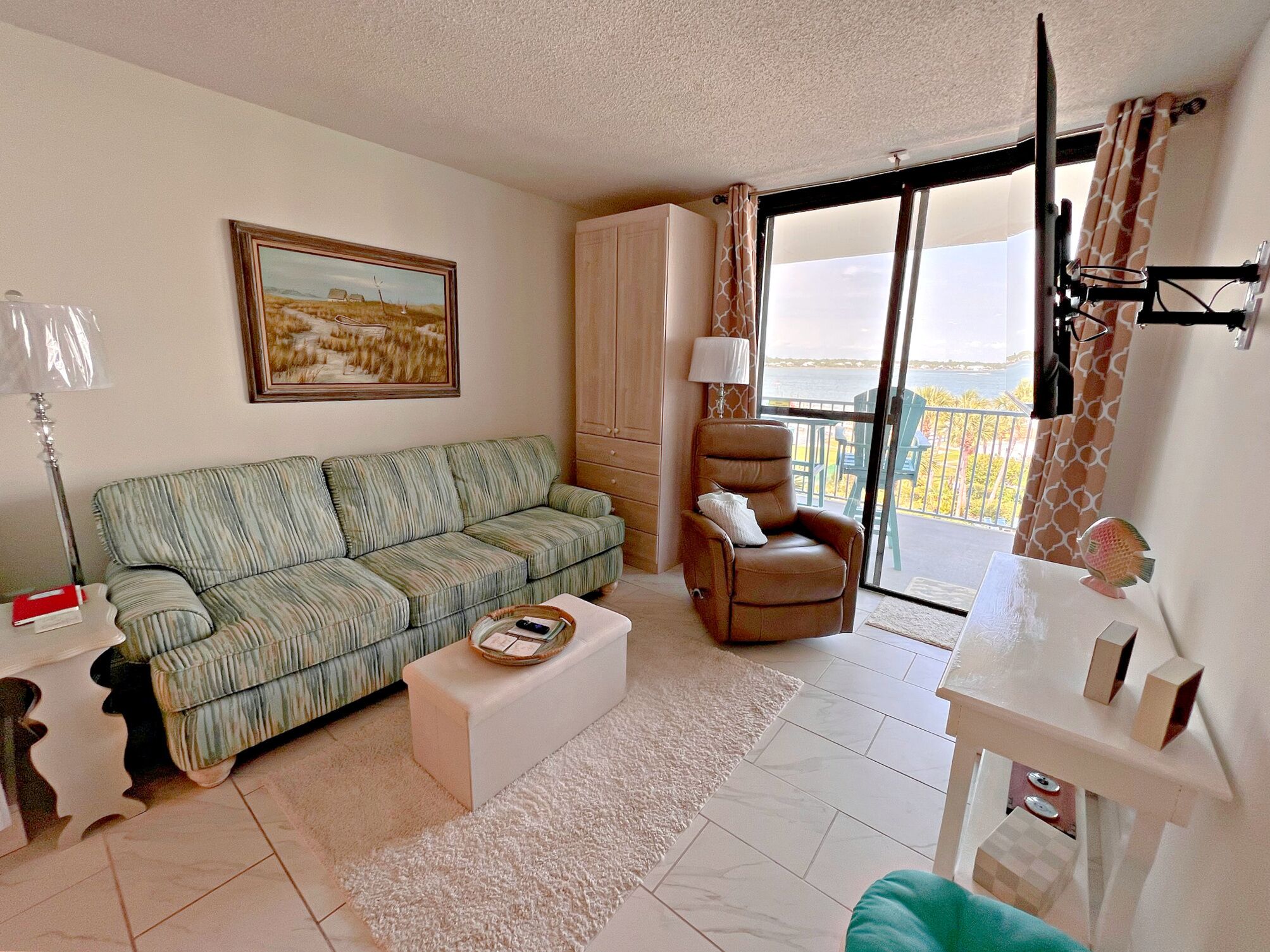 Una sala de estar con sofá, sillón y vistas al exterior.