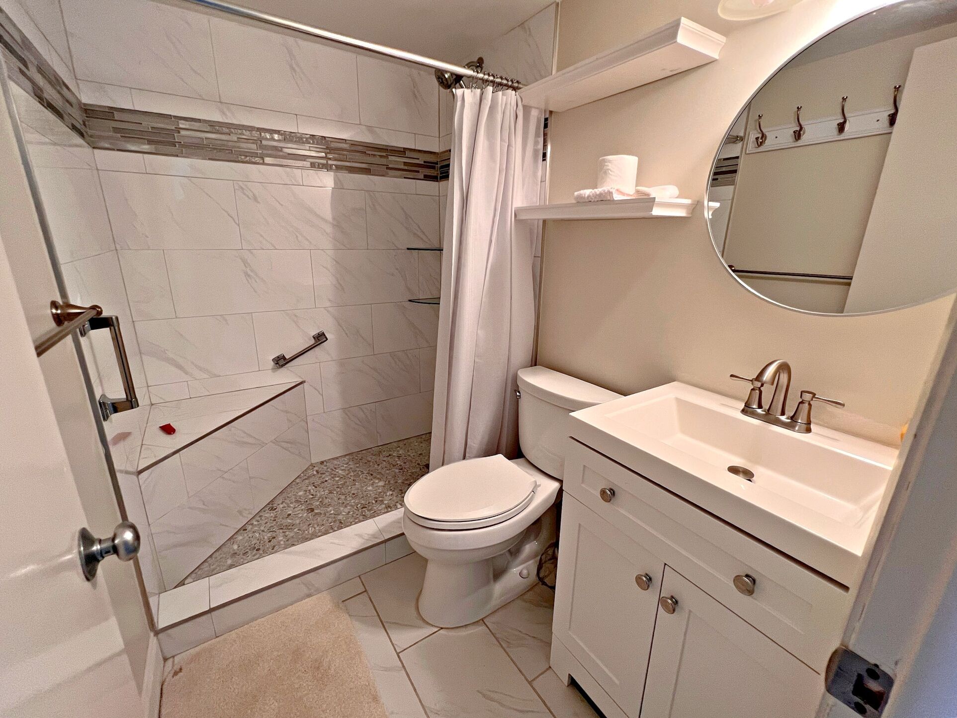 Un bagno con doccia, servizi igienici, lavandino e specchio.
