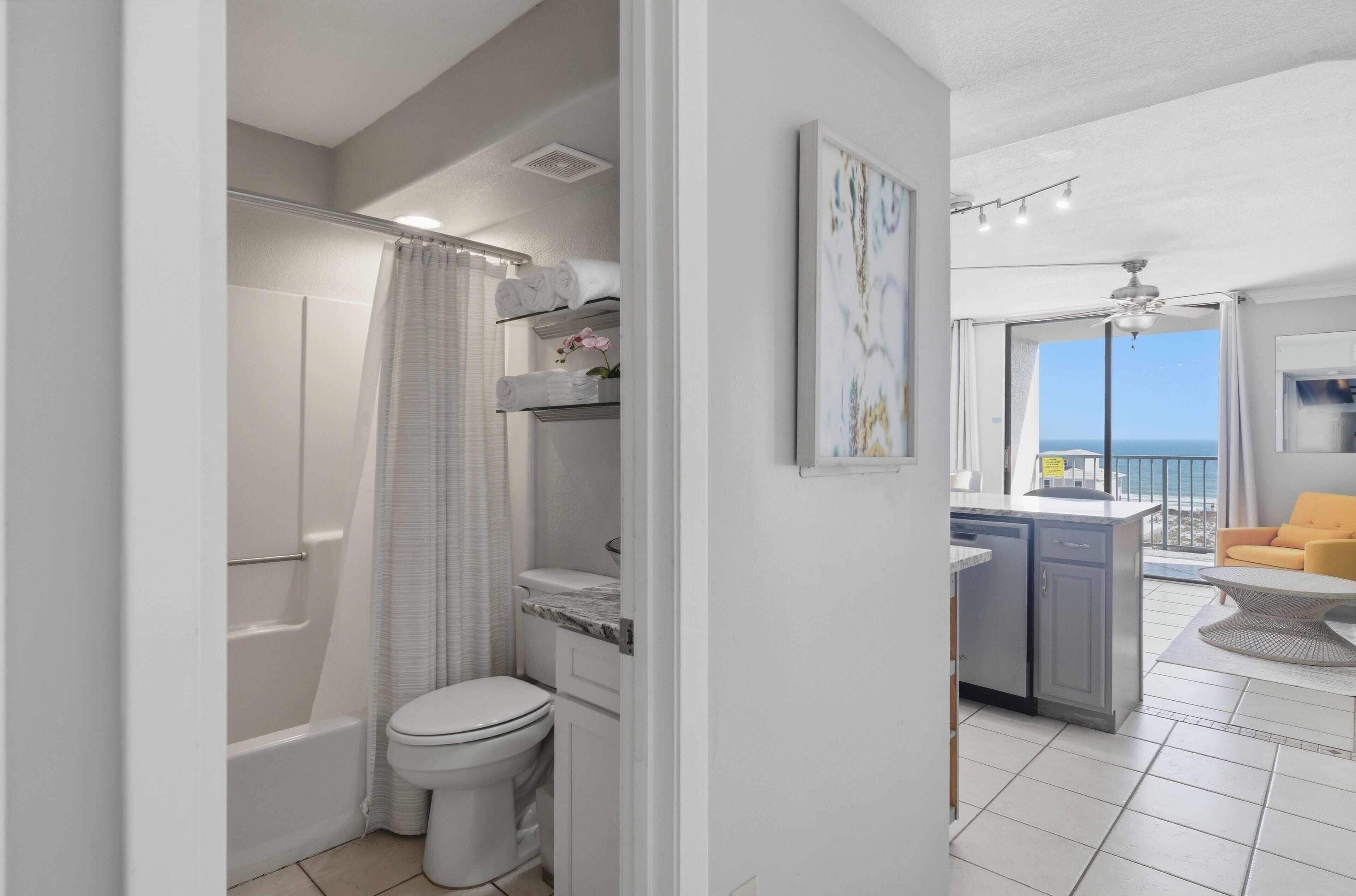 Een moderne badkamer met douche, toilet en balkon met uitzicht.