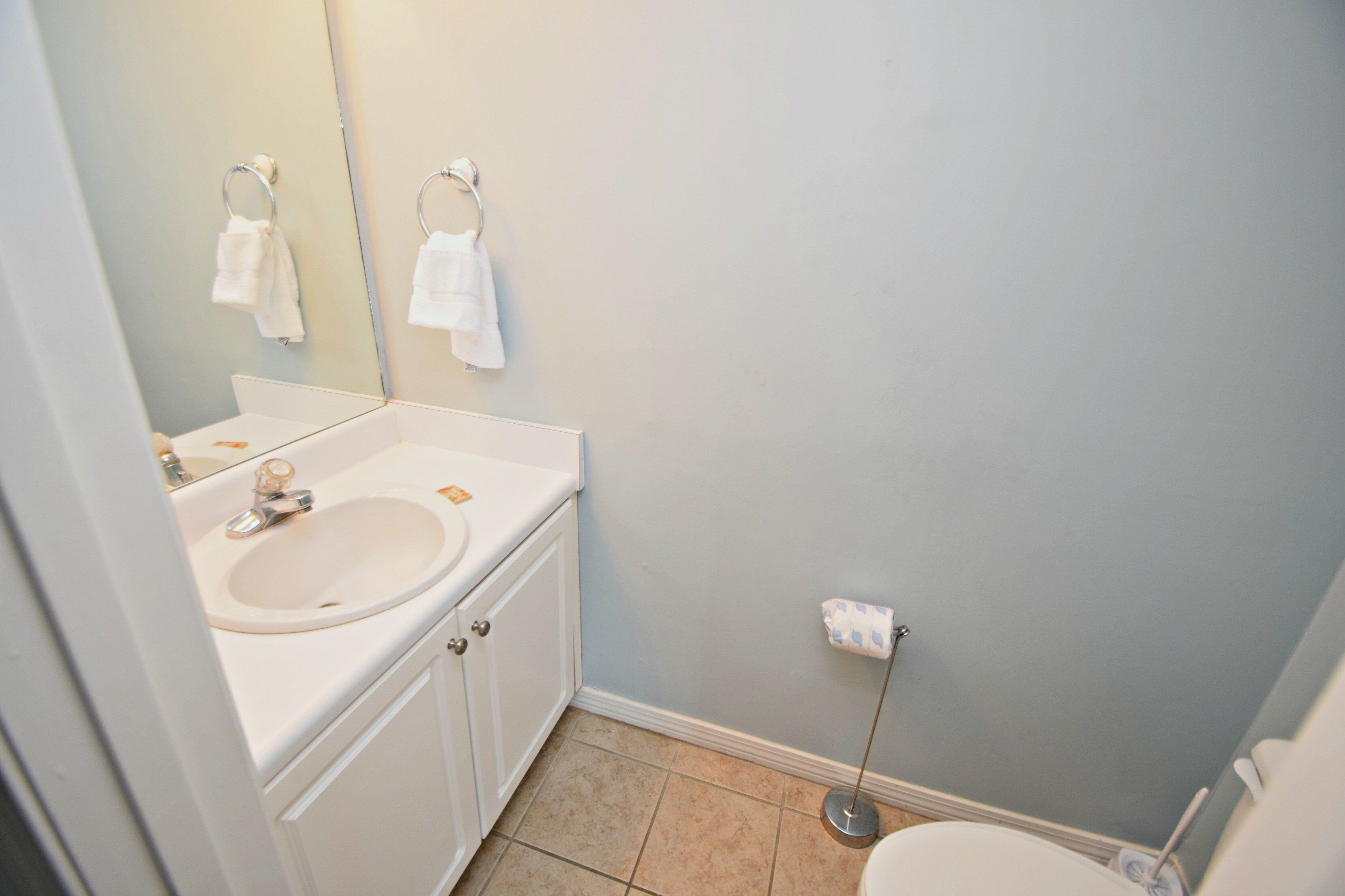 A bathroom with a sink, mirror, and toilet.