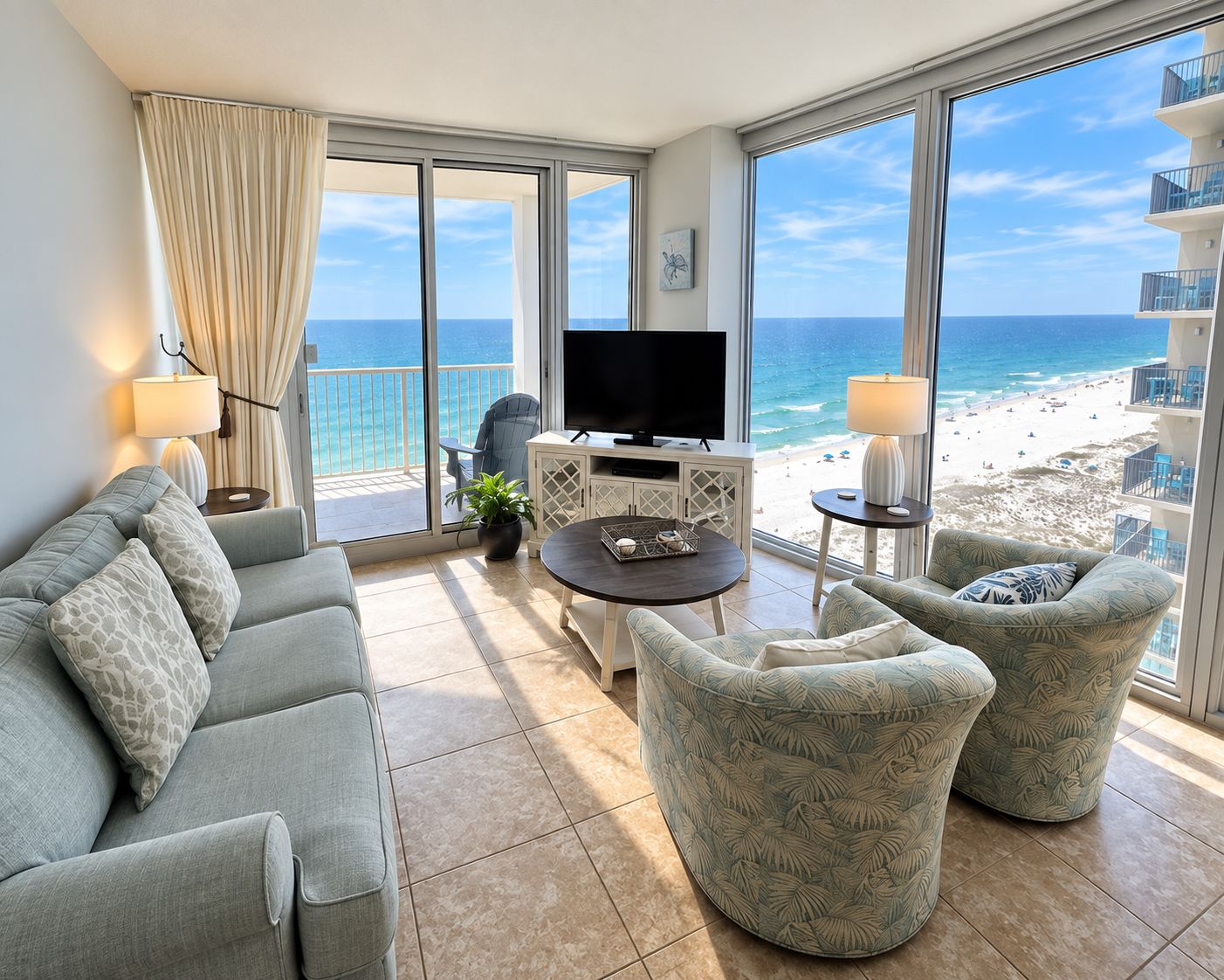 Un balcón con televisor, zona de estar y vistas a la playa.