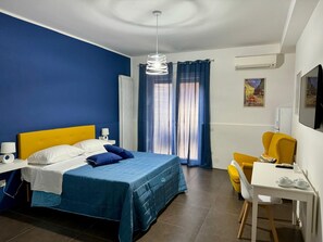 A hotel room with a bed, a desk, a chair, and a TV. - Il Ruggi  (Salerno)