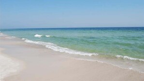 Ein Strand mit klarem, blauem Wasser und einem sandigen Ufer.