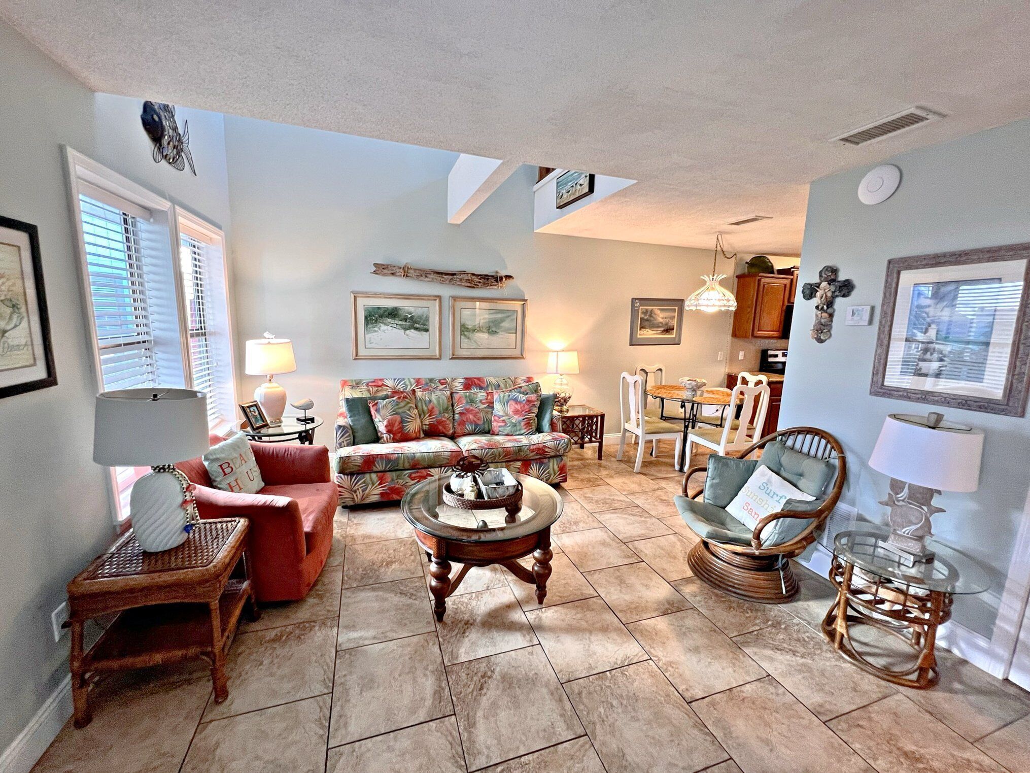 A living room with a sofa, chairs, a coffee table, and a dining area with a table and chairs.