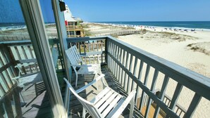 A beach view from a balcony with white chairs and a wooden deck. - Ocean Reef (Gulf Shores)
