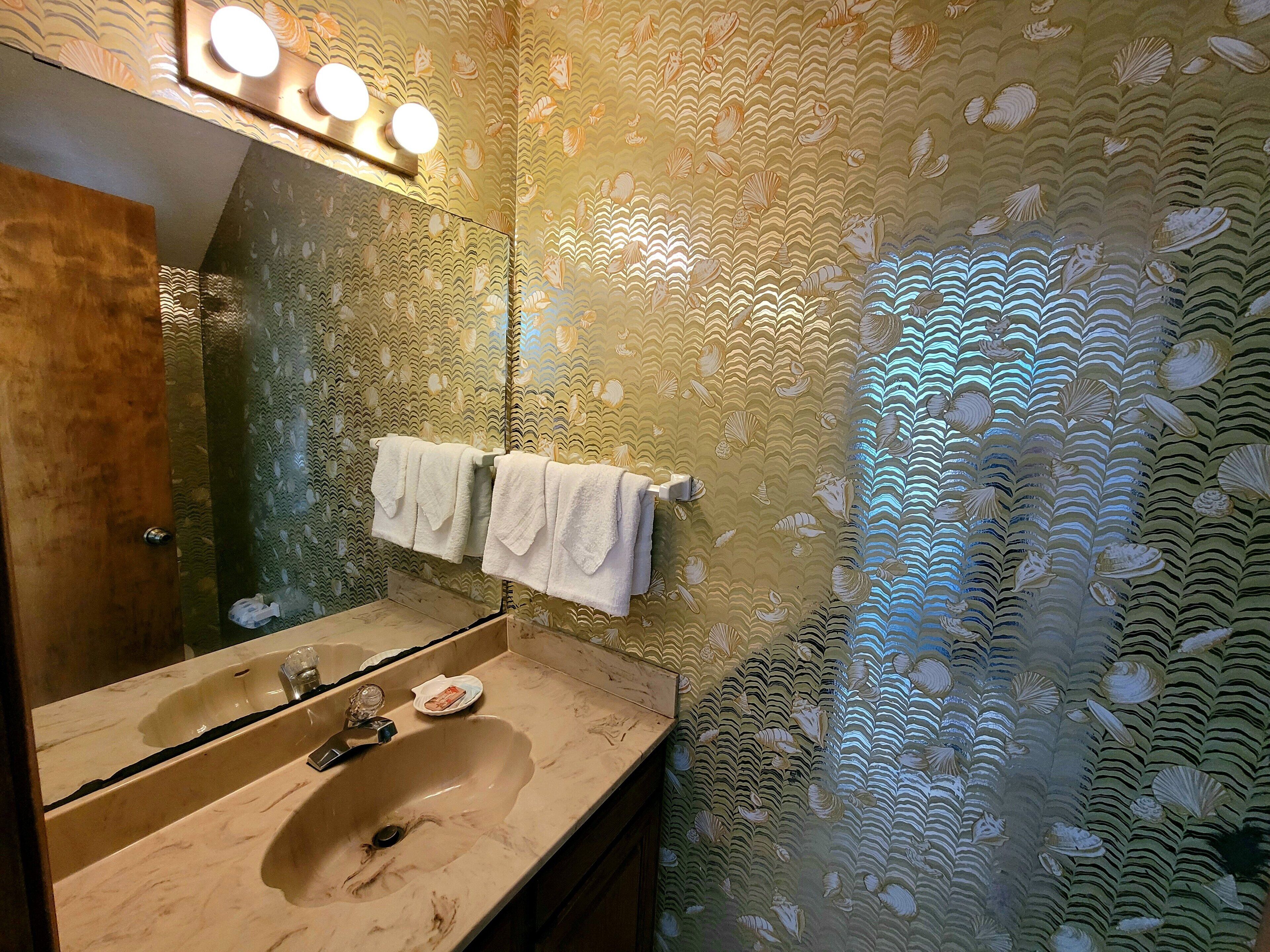 A bathroom with a sink, mirror, and towel rack.