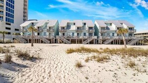 A beachfront hotel with multiple-story buildings, balconies, and a sandy beach in the foreground. - Ocean Reef (Gulf Shores)
