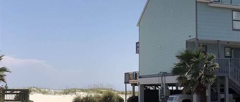Ein Gebäude direkt am Strand mit Parkplatz und überdachtem Zugang.