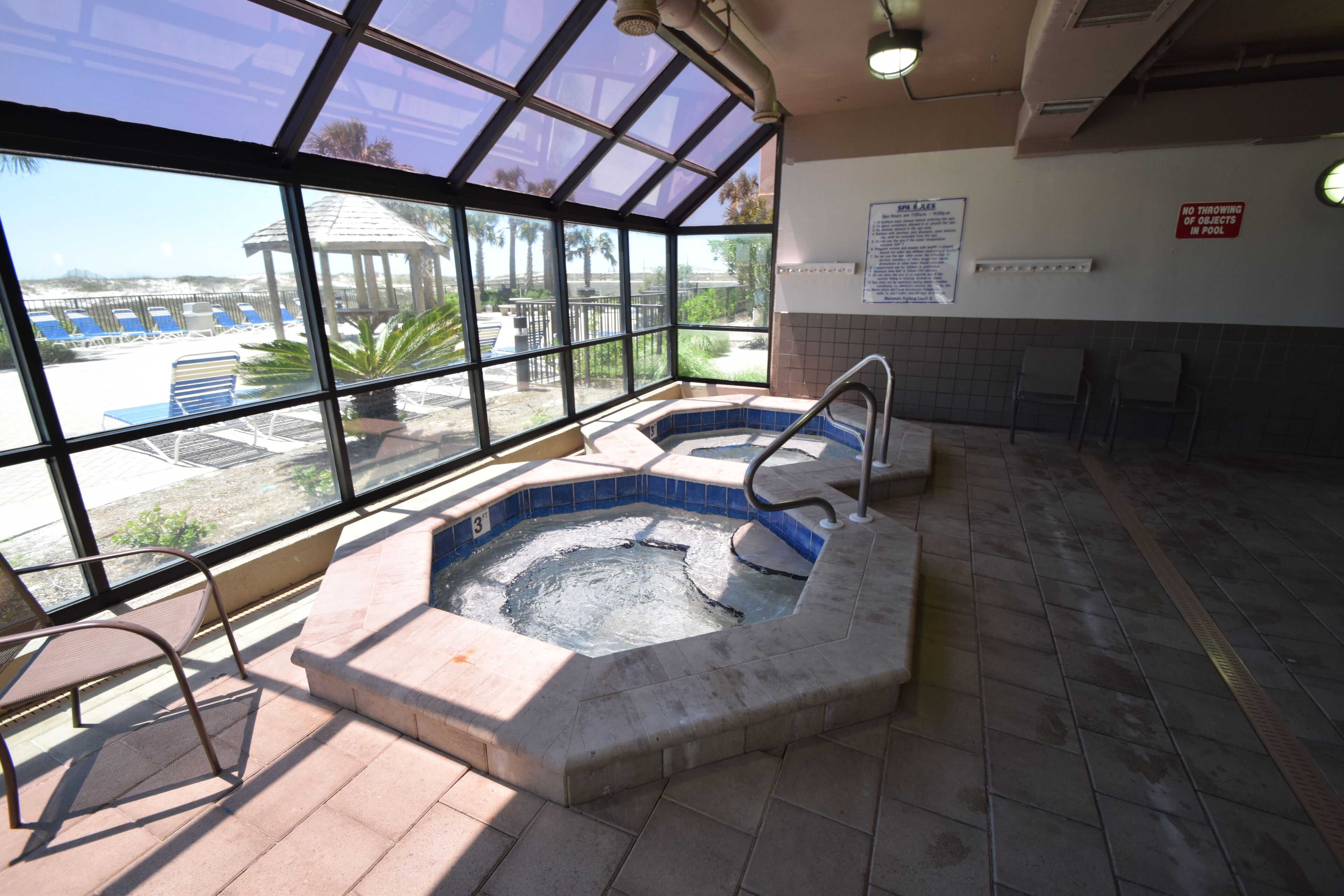 Ein Whirlpoolbereich mit Blick auf einen Pool und Palmen.