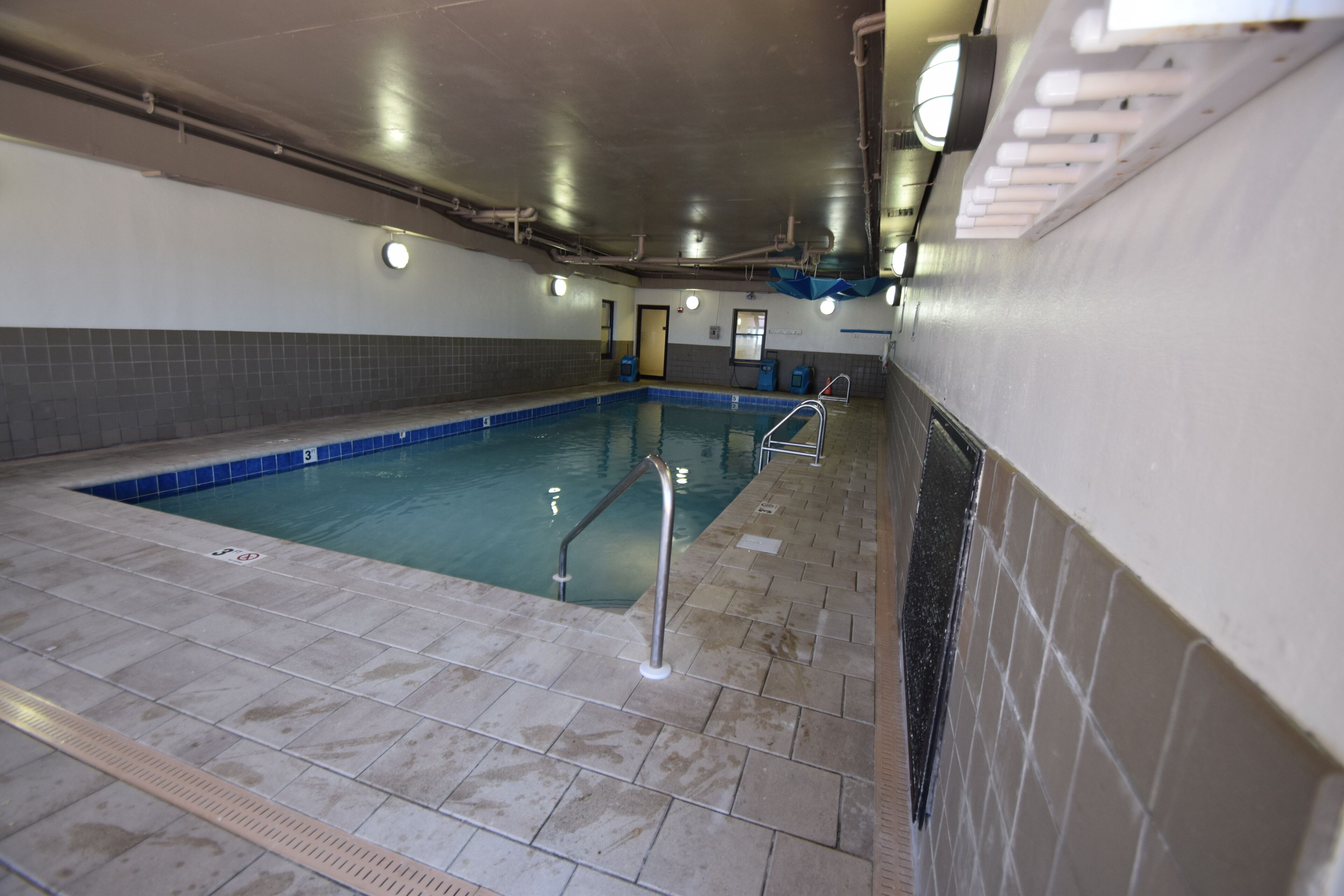 Une piscine intérieure avec des murs carrelés et une zone de baignade bien délimitée.