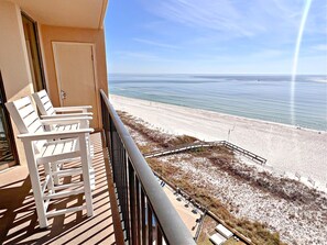 A balcony with white chairs, a view of the beach, and a clear sky. - Phoenix V (Orange Beach)