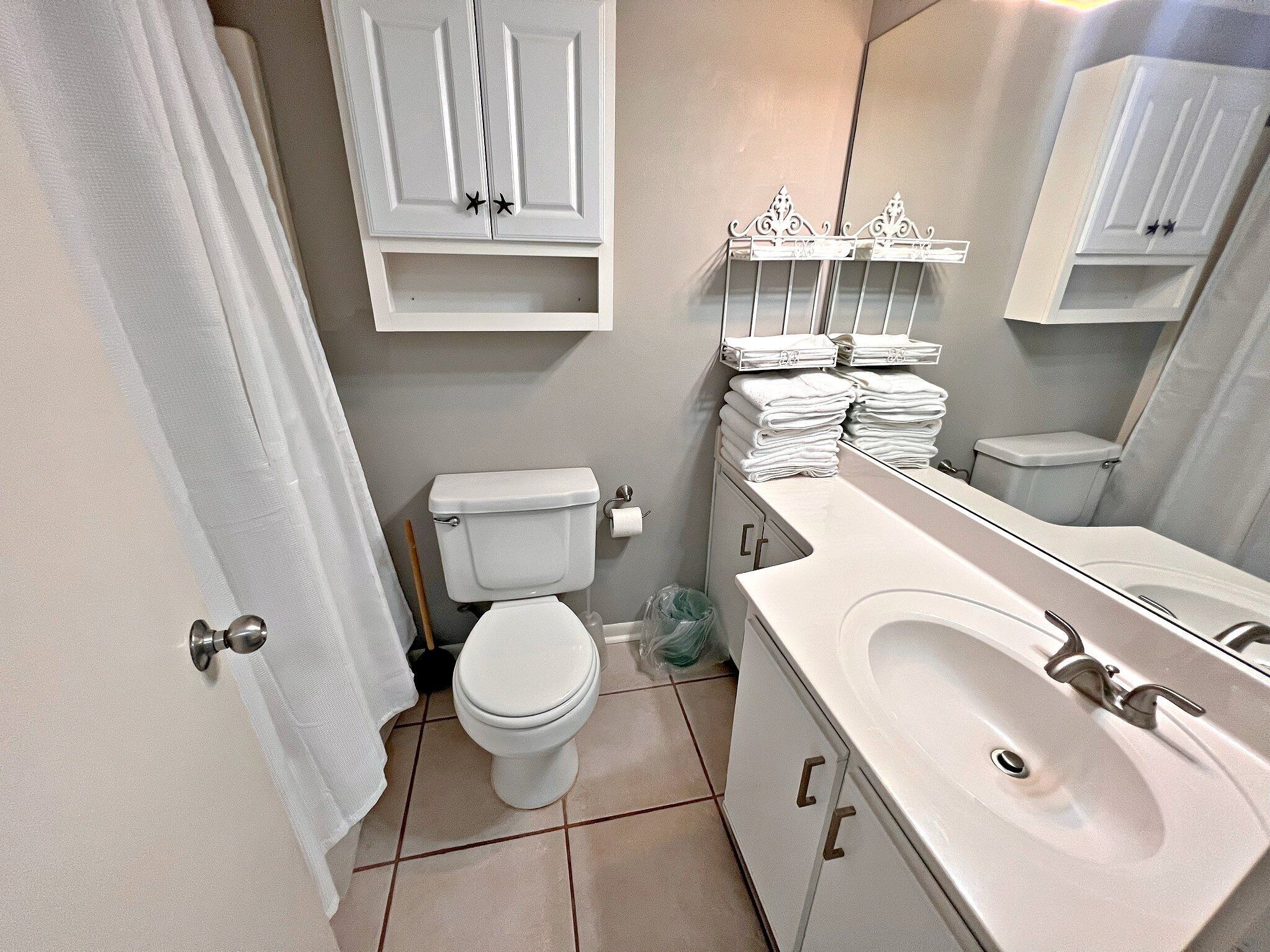 A bathroom with a toilet, sink, and towel rack.