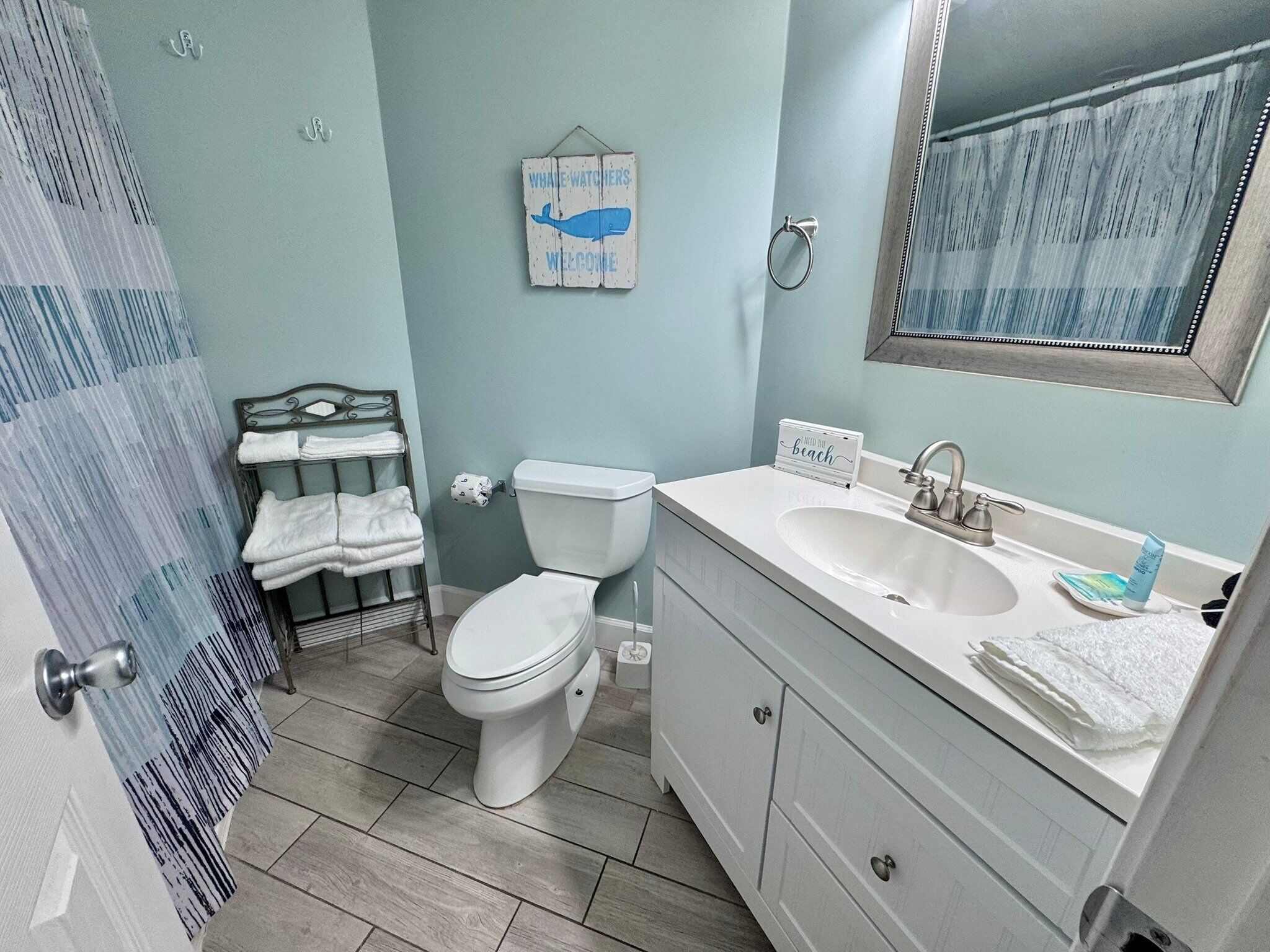 A bathroom with a toilet, sink, and a towel rack.