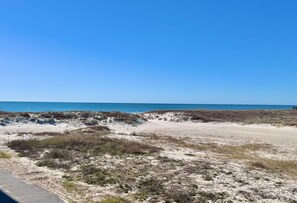 A beach with sand dunes and a clear blue sky. - Regatta (Gulf Shores)