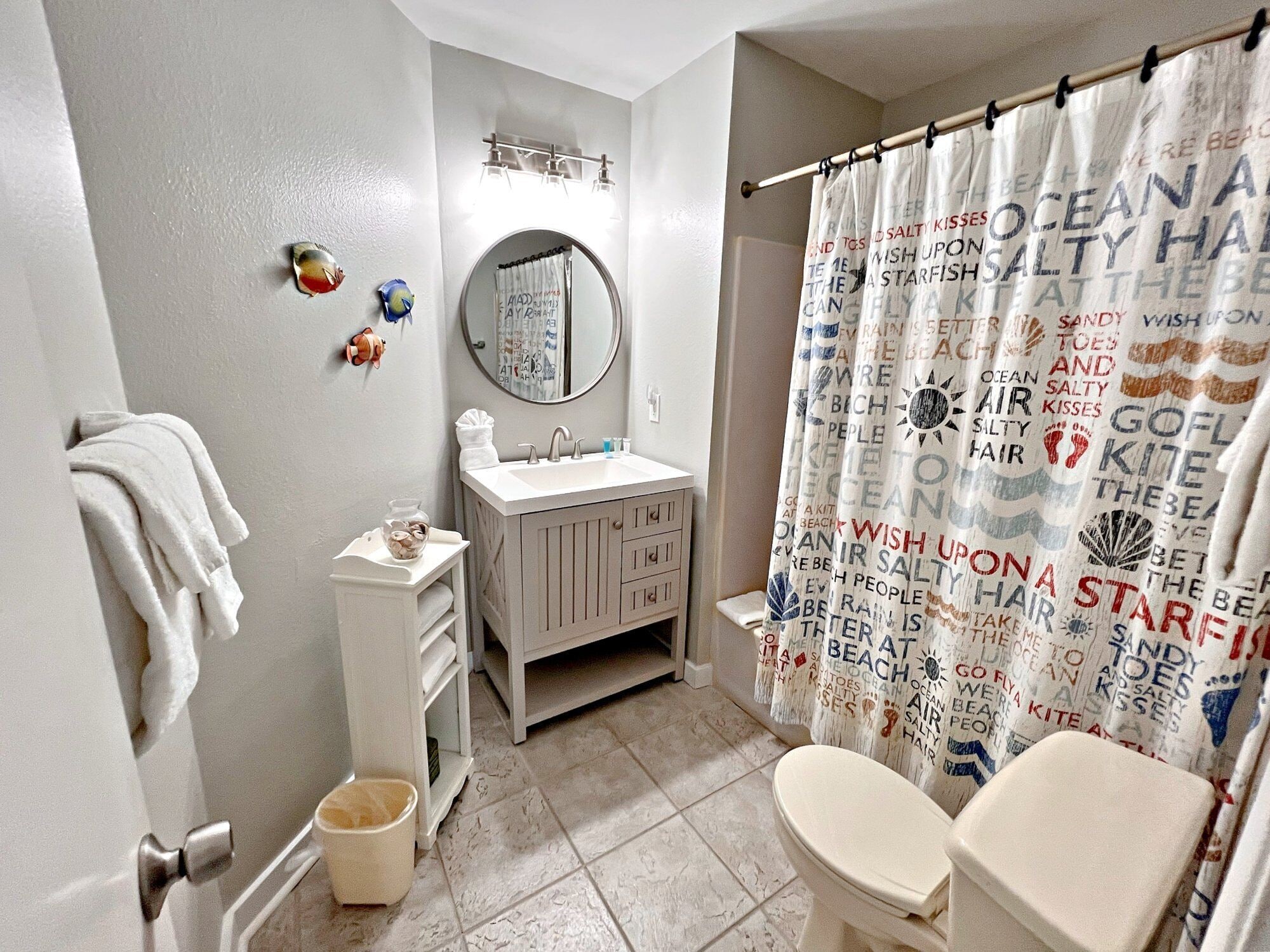A bathroom with a toilet, sink, and shower curtain with text.