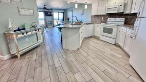 A kitchen with white cabinets, a granite countertop, and a microwave. - Regatta (Gulf Shores)