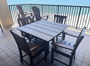 A wooden table and chairs on a balcony with a view of the beach. - Romar House (Orange Beach)