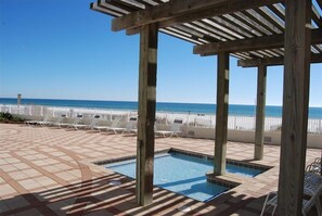 Eine Holz-Pergola über einem Swimmingpool mit Blick auf den Strand.