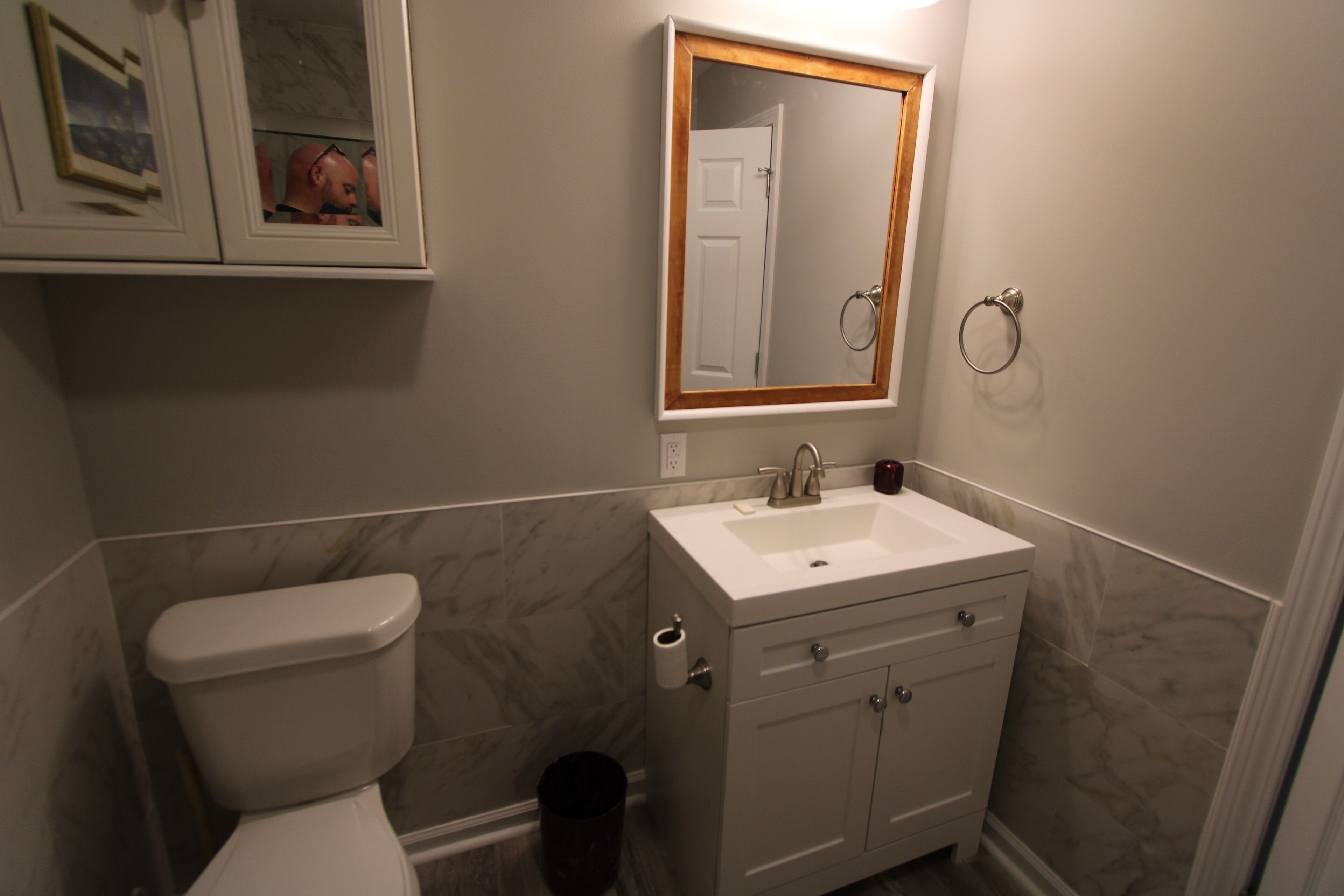Une salle de bain avec des toilettes, un lavabo et un meuble de rangement.