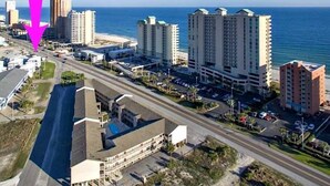 A coastal cityscape with high-rise buildings, a beach, and a road. - Spinnaker Pointe (Gulf Shores)