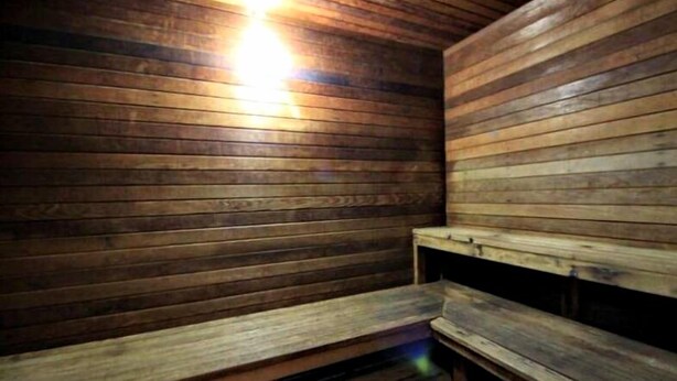 A sauna room with wooden benches and slatted walls. - Summerhouse (Orange Beach)