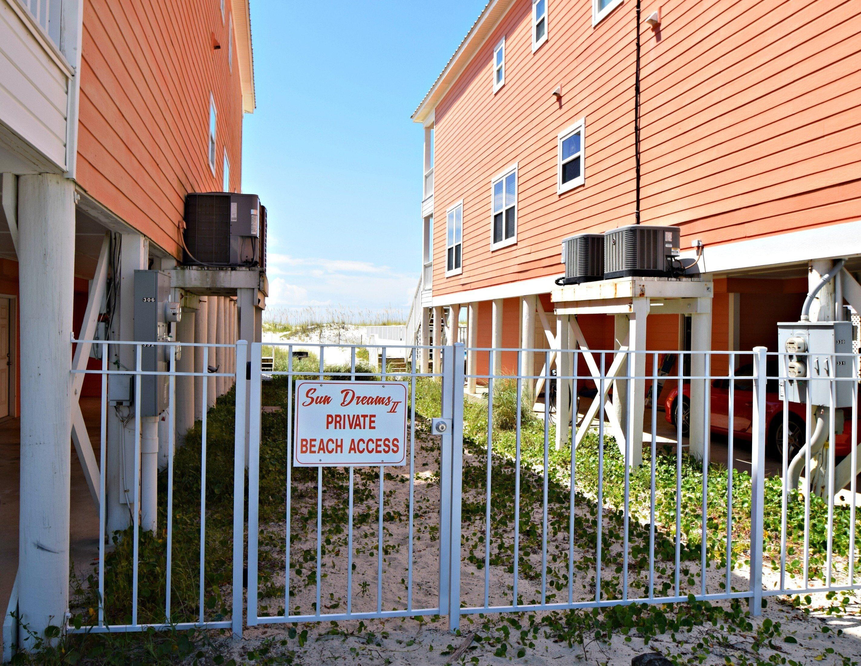 Un espace clos, agrémenté d’un panneau indiquant qu’il donne accès à une plage privée.