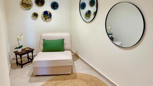 A room with a bed, a small table with a plant, and wall art. - Nice Oldtown Appartment With two Floors and Great sea View (La Vila Joiosa)
