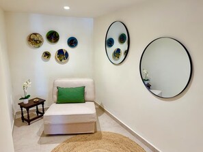 Una stanza con un letto, un tavolino con una pianta e decorazioni alle pareti.