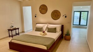 A bedroom with a large bed, a bedside table with a lamp, and a potted plant. - Nice Oldtown Appartment With two Floors and Great sea View (La Vila Joiosa)