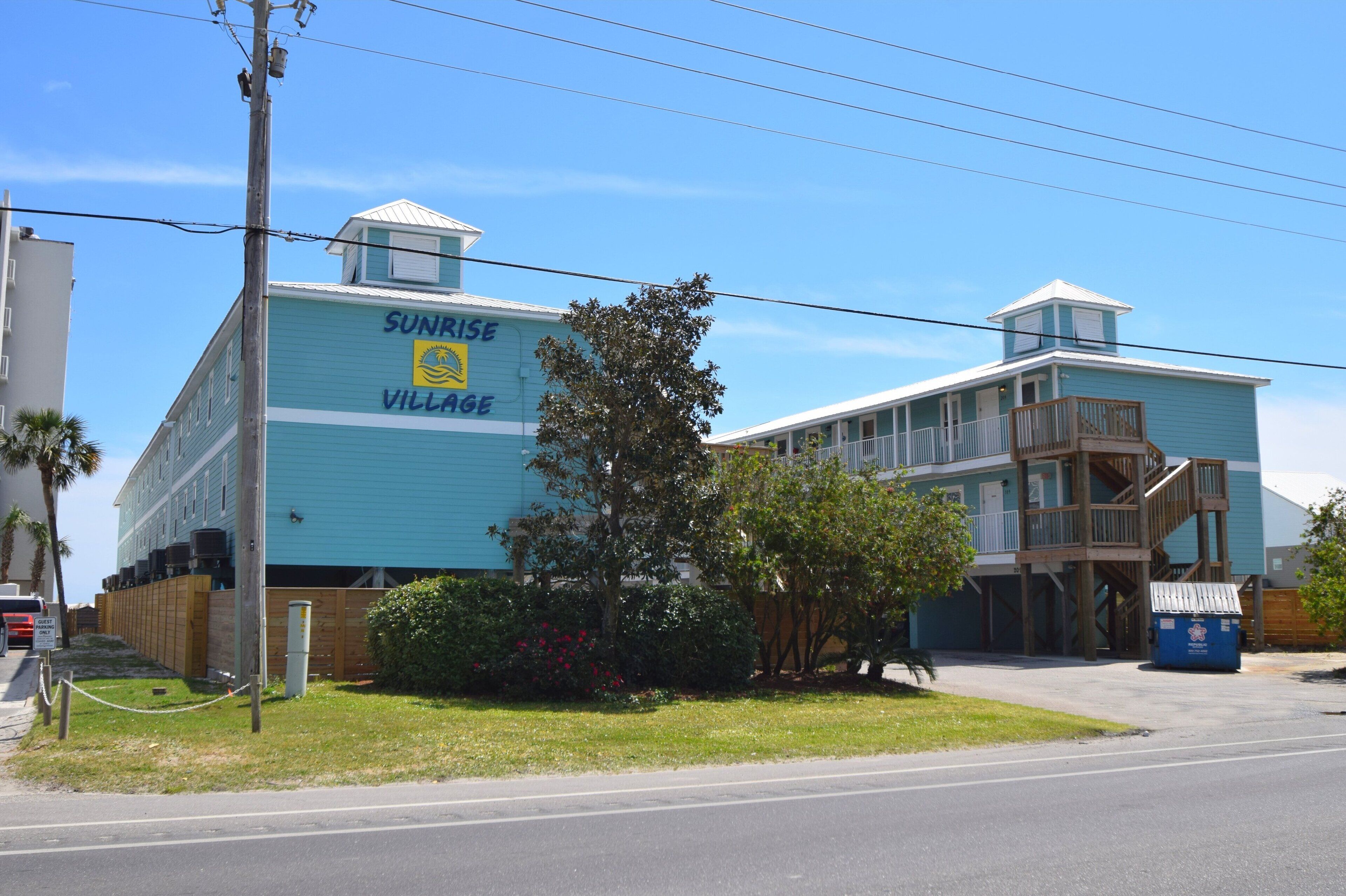 A two-story building with a sign reading "Sunrise Village."