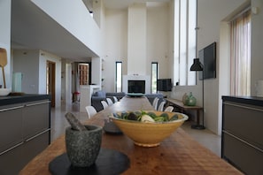 A modern kitchen with a wooden table, a bowl of salad, and a stone mortar. - Luxury Holiday Villa with private swimming pool amidst 300 olive trees (Ronda)